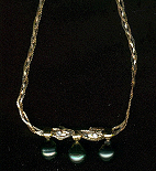Pendentif trois or 24 cara avec trois perles de Tahiti et deux diamants.