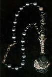 Collier perles noires grises blanches et or sur galet noir. 